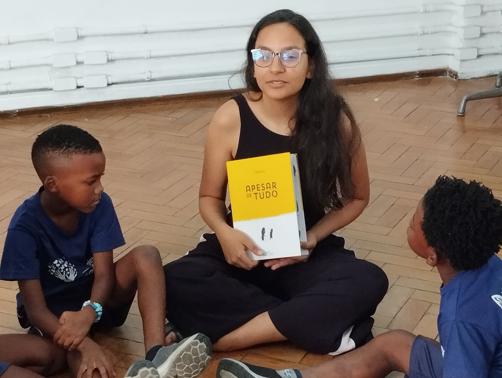 Criança apresentando um livro de leitura