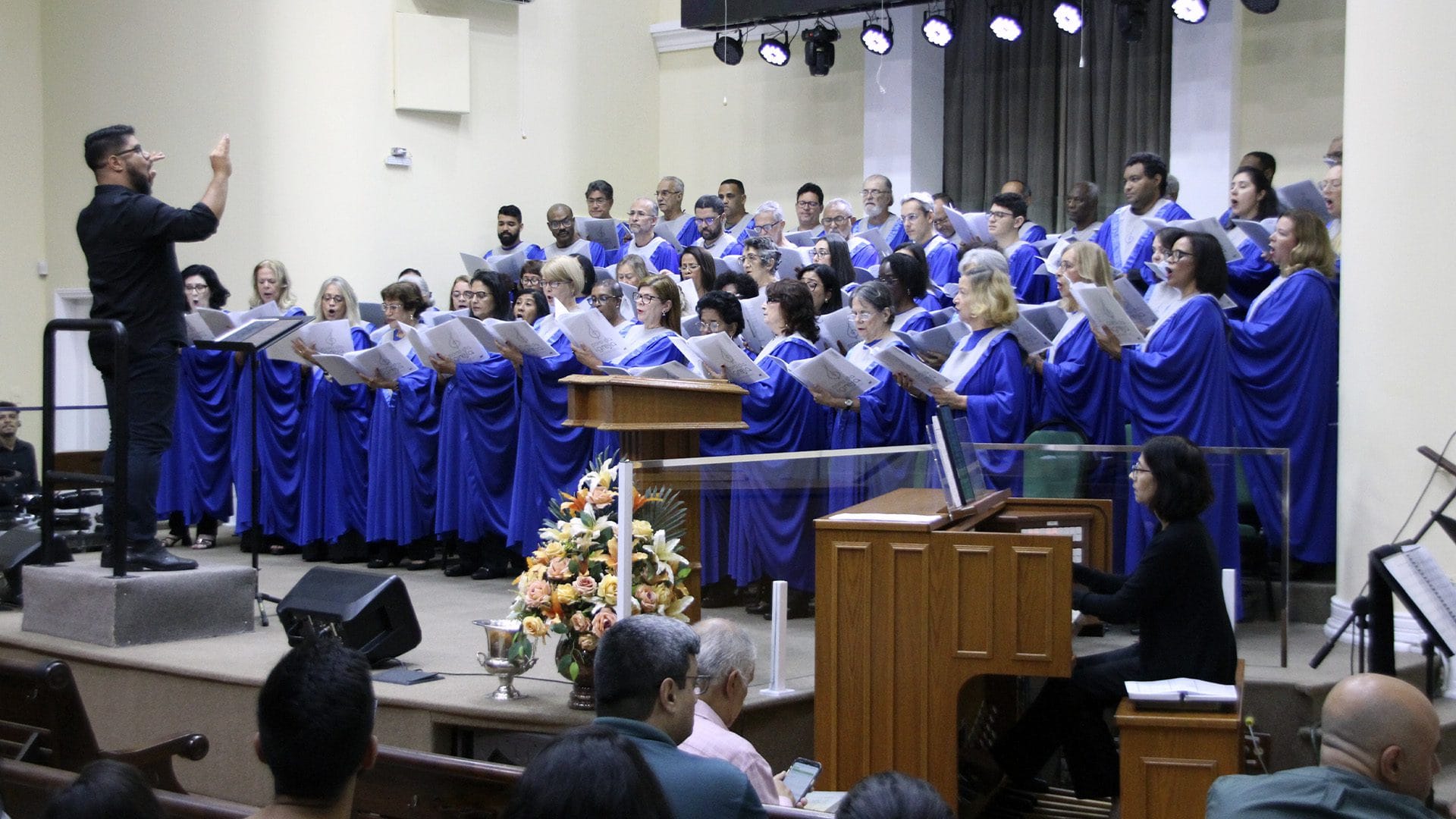 Coro da Igreja com becas azuis durante culto