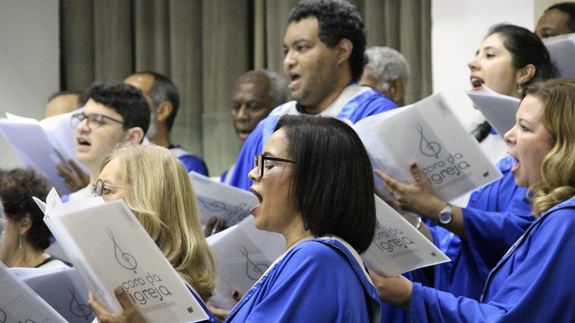 Coristas do Coro da Igreja cantando com partituras
